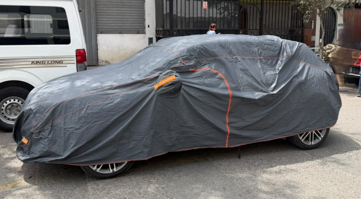 El mismo Kia protegido con un cobertor Car Cover Perú con costuras naranjas y bandas reflectivas